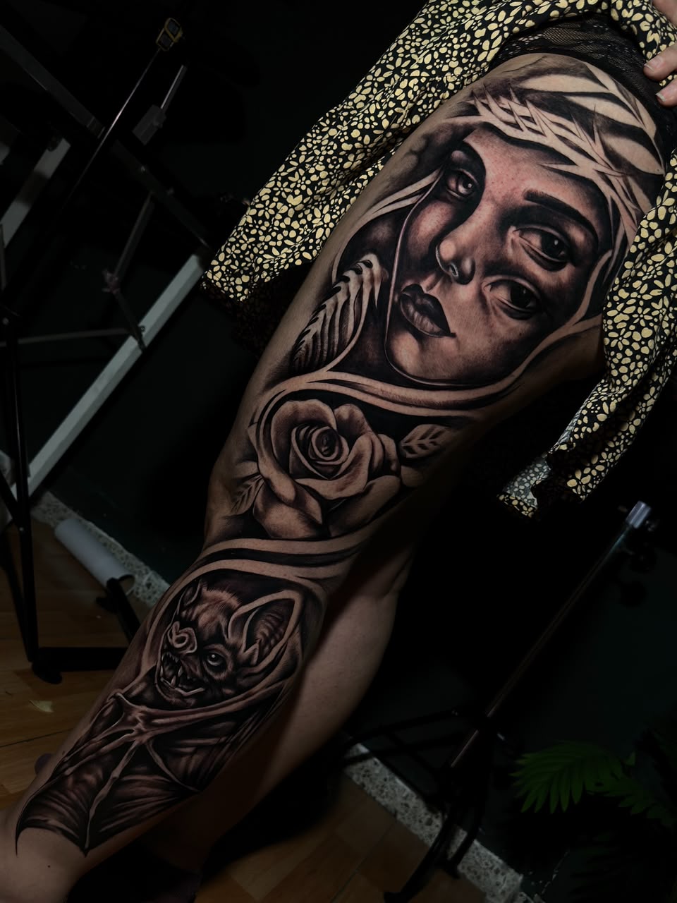 Tatuaje de retrato, rosa y sombreado en negro sobre el brazo de un cliente